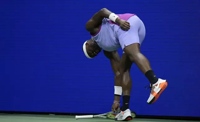 Frances Tiafoe, of the United States, picks up his racket during the men's singles semifinals against Taylor Fritz, of the United States, of the U.S. Open tennis championships, Friday, Sept. 6, 2024, in New York. (AP Photo/Seth Wenig)