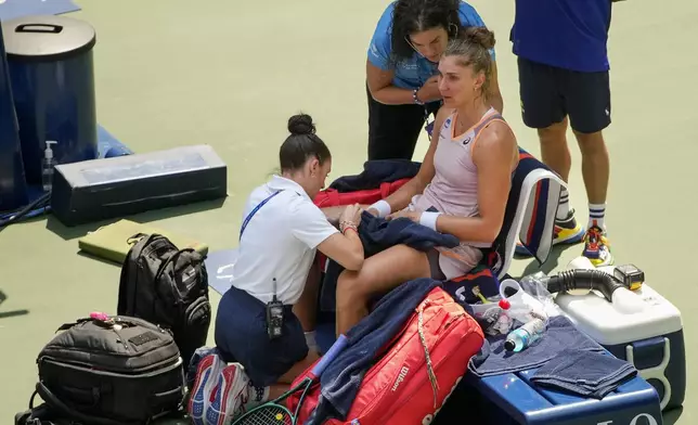 Beatriz Haddad Maia, of Brazil, is checked by medical personnel during the second set against Karolina Muchova, of the Czech Republic, during the quarterfinals of the U.S. Open tennis championships, Wednesday, Sept. 4, 2024, in New York. (AP Photo/Kirsty Wigglesworth)