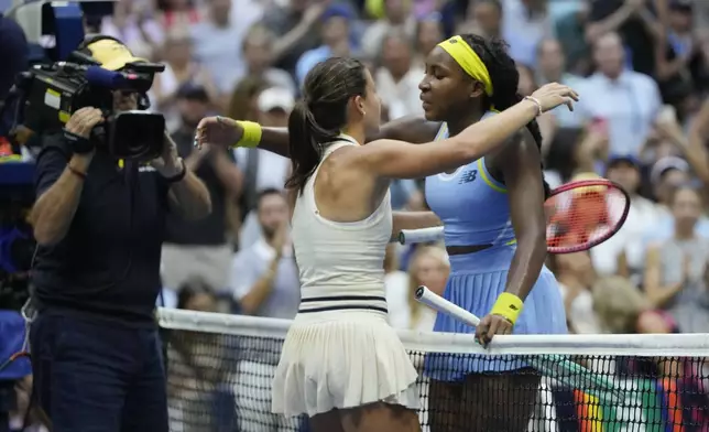 Emma Navarro, center, of the United States, embraces Coco Gauff, of the United States, after defeating her in the fourth round of the U.S. Open tennis championships, Sunday, Sept. 1, in New York. 2024. (AP Photo/Pamela Smith)