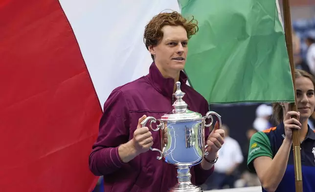 Jannik Sinner, of Italy, holds up the championship trophy after defeating Taylor Fritz, of the United States, in the men's singles final of the U.S. Open tennis championships, Sunday, Sept. 8, 2024, in New York. (AP Photo/Julia Nikhinson)