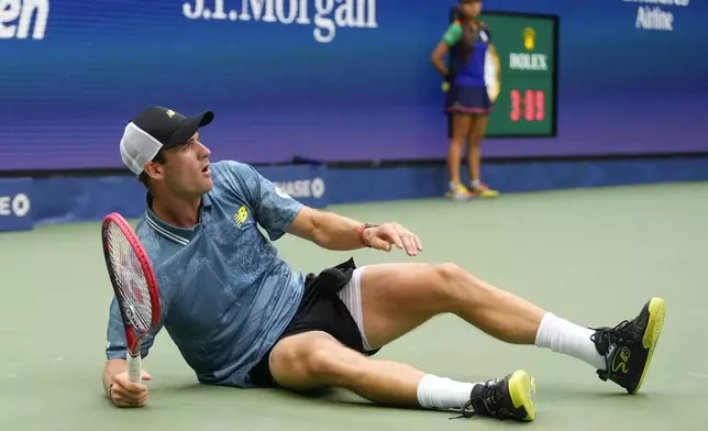 Tommy Paul, of the United States, falls to the court after returning a shot to Gabriel Diallo, of Canada, during the third round of the U.S. Open tennis championships, Saturday, Aug. 31, 2024, in New York. (AP Photo/Kirsty Wigglesworth)