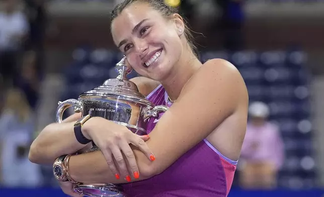 Aryna Sabalenka, of Belarus, poses for photos with the championship trophy after defeating Jessica Pegula, of the United States, in the women's singles final of the U.S. Open tennis championships, Saturday, Sept. 7, 2024, in New York. (AP Photo/Frank Franklin II)