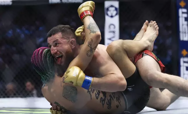 Merab Dvalishvili, top, fights Sean O'Malley in a bantamweight mixed martial arts title bout during UFC 306 at the Sphere, Saturday, Sept. 14, 2024, in Las Vegas. (Wade Vandervort/Las Vegas Sun via AP)