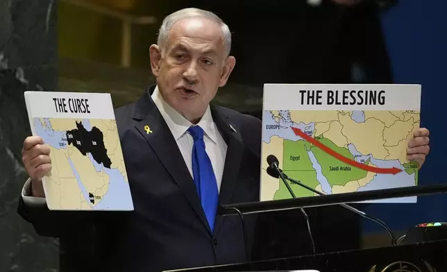 Prime Minister of Israel Benjamin Netanyahu hold signs as he addresses the 79th session of the United Nations General Assembly, Friday, Sept. 27, 2024. (AP Photo/Pamela Smith)