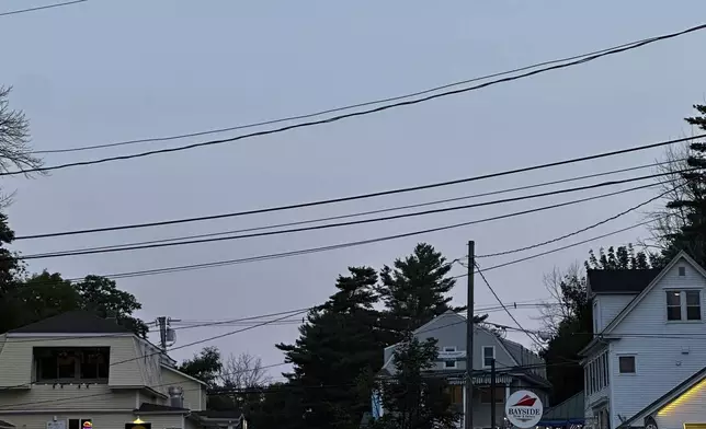 The moon rises over Alton, New Hampshire as Canada and northern U.S. cities experience moderate solar storms that could spark aurora borealis, Thursday, Sept. 12, 2024. (AP Photo/Caleb Jones)