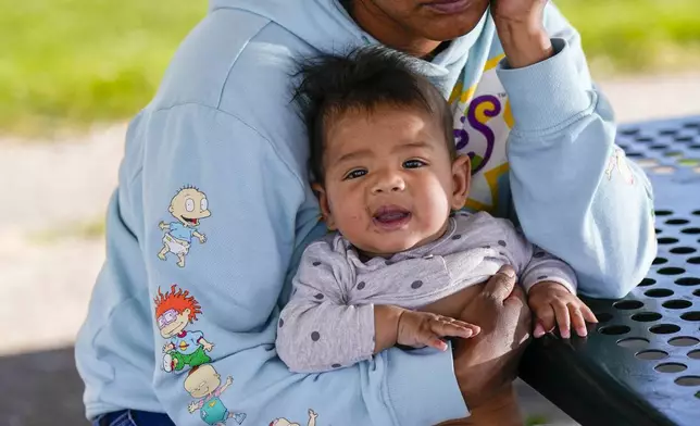 Ivanni Herrera holds her baby Milan Guzman during an interview in a park Friday, May 18, 2024, in Aurora, Colo. (AP Photo/Jack Dempsey)