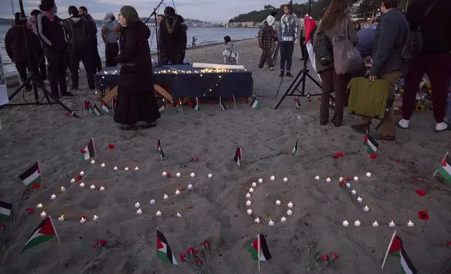 Ezgi is spelled in candles on the sand during a vigil on Alki Beach for Aysenur Ezgi Eygi, a 26-year-old activist from Seattle, who was killed recently in the West Bank, Wednesday, Sept. 11, 2024, in Seattle. (AP Photo/John Froschauer)