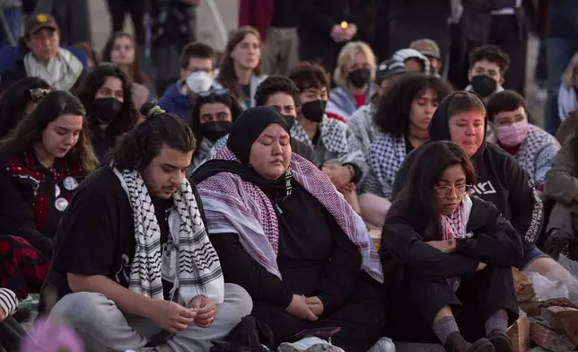 Attendees bow during a silent prayer at a vigil on Alki Beach for Aysenur Ezgi Eygi, a 26-year-old activist from Seattle, who was killed recently in the West Bank, Wednesday, Sept. 11, 2024, in Seattle. (AP Photo/John Froschauer)