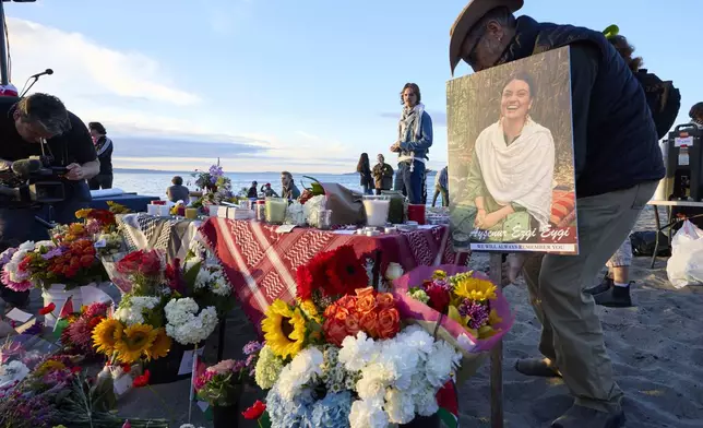 A photo is placed among flowers in memory of the death of the 26-year old Aysenur Ezgi Eygi at vigil on Alki Beach, killed recently in the occupied West Bank, Wednesday, Sept. 11, 2024, in Seattle. Eygi grew up in Seattle, attended Seattle Public Schools and graduated from the University of Washington. (AP Photo/John Froschauer)