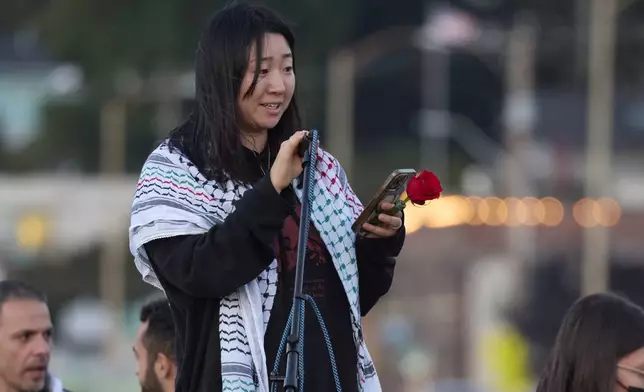 Sue Han, a friend of the 26-year old Aysenur Ezgi Eygi, killed recently in the occupied West Bank, during vigil on Alki Beach, Wednesday, Sept. 11, 2024, in Seattle. Eygi grew up in Seattle, attended Seattle Public Schools and graduated from the University of Washington. (AP Photo/John Froschauer)