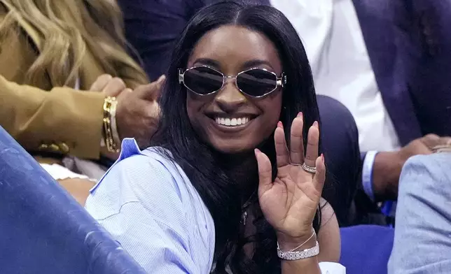 Olympic gold medalist Simone Biles waves during a break in a match between Jessica Pegula, of the United States, and Iga Świątek, of Poland, during the quarterfinals of the U.S. Open tennis championships, Wednesday, Sept. 4, 2024, in New York. (AP Photo/Eduardo Munoz Alvarez)