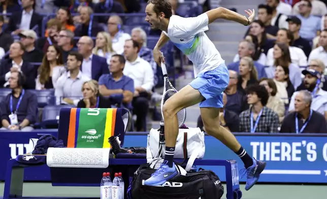 Daniil Medvedev, of Russia, leaps over the player's bench on a return against Jannik Sinner, of Italy, during the quarterfinals of the U.S. Open tennis championships, Wednesday, Sept. 4, 2024, in New York. (AP Photo/Adam Hunger)