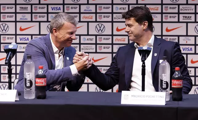 Mauricio Pochettino, right, the newly appointed head coach of the United States men's national soccer team, shakes hands with U.S. soccer sporting director Matt Crocker at a press conference Friday, Sept. 13, 2024, in New York. (AP Photo/Adam Hunger)