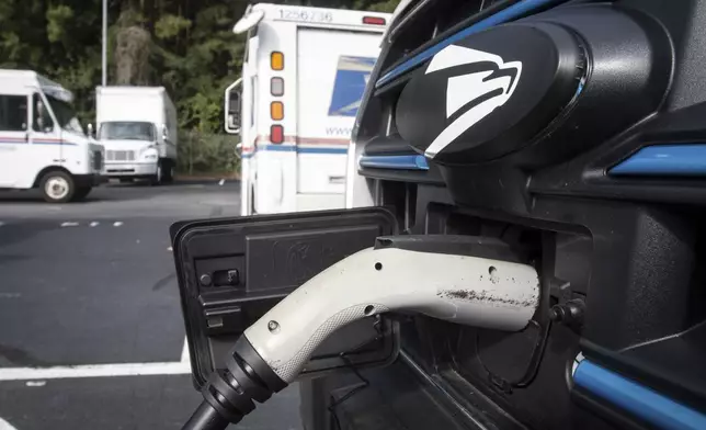 New mail delivery vehicles are charging at a station at a post office on Thursday, Sept. 5, 2024, in Athens Ga. (AP Photo/Ron Harris)