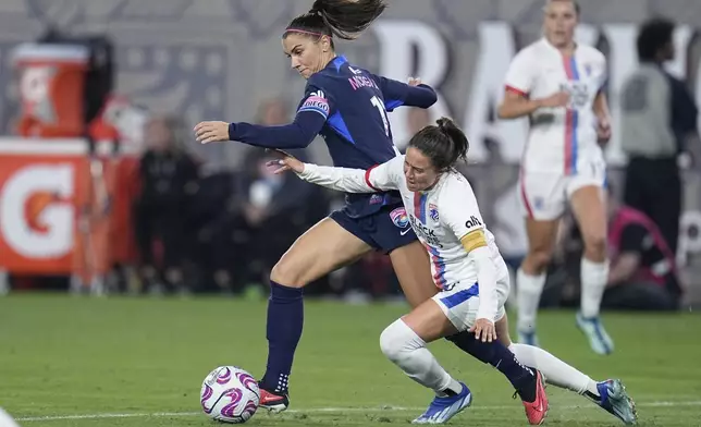 FILE - San Diego Wave forward Alex Morgan, left, controls the ball as OL Reign defender Lauren Barnes defends during the second half of an NWSL semifinal playoff soccer match Sunday, Nov. 5, 2023, in San Diego. (AP Photo/Gregory Bull, File)