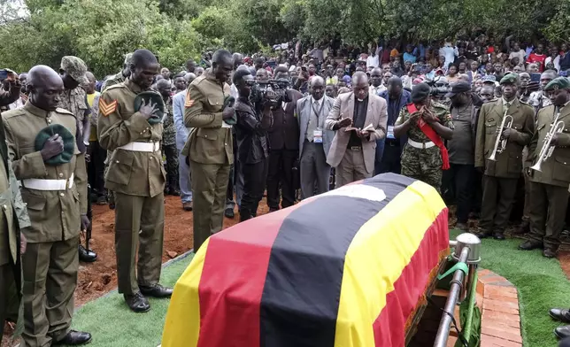 Members of the Uganda People's Defense Force pay their respects at the funeral of Ugandan Olympic athlete Rebecca Cheptegei as her casket is lowered into the grave in Kapkoros, Bukwo District, Uganda, on Saturday, Sept. 14. 2024. (AP Photo/Hajarah Nalwadda)