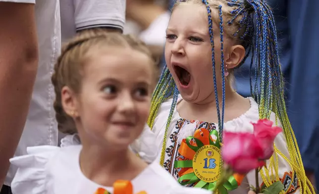 Children attend the traditional ceremony for the first day of school in Zaporizhzhia, Ukraine, Sunday Sept. 1, 2024. Zaporizhzhia schoolchildren celebrated the traditional first day of school near the frontline. With the front just 40 kilometers away, the war is never far from the minds of teachers and families. (AP Photo/Evgeniy Maloletka)