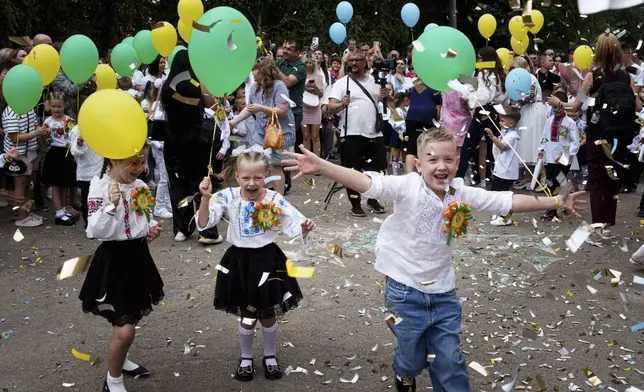 First-grades attend the traditional ceremony for the first day of school in Zaporizhzhia, Ukraine, Sunday Sept. 1, 2024. Zaporizhzhia schoolchildren celebrated the traditional first day of school near the frontline. With the front just 40 kilometers away, the war is never far from the minds of teachers and families. (AP Photo/Evgeniy Maloletka)