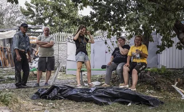 People cry near the body of a relative who was killed in a Russian strike on the residential neighbourhood in Cherkaska Lozova, Kharkiv region, Ukraine, Saturday Aug. 31. 2024. (AP Photo/Yevhen Titov)