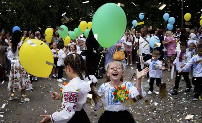 First-grades attend the traditional ceremony for the first day of school in Zaporizhzhia, Ukraine, Sunday Sept. 1, 2024. Zaporizhzhia schoolchildren celebrated the traditional first day of school near the frontline. With the front just 40 kilometers away, the war is never far from the minds of teachers and families. (AP Photo/Evgeniy Maloletka)