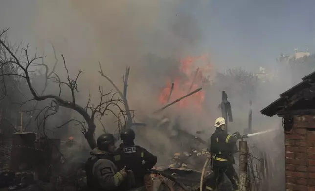 Rescue workers extinguish a fire burning residential buildings after twin Russian bombings in Kharkiv, Ukraine, Sunday Sept. 1, 2024. (AP Photo/George Ivanchenko)