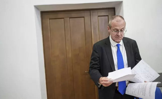 Doctor Hans Henri P. Kluge, WHO Regional Director for Europe, reads notes before a press conference in Kyiv, Ukraine, Thursday Sept. 12, 2024. (AP Photo/Evgeniy Maloletka)