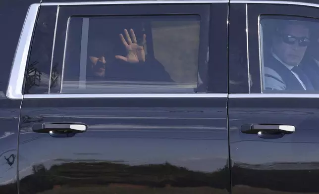 Ukrainian President Volodymyr Zelenskyy waves from the back seat of a U.S. Secret Service vehicle as his motorcade departs the Wilkes-Barre/Scranton International Airport in Pittston Township, Pa. en route to the Scranton Army Ammunition Plant in Scranton, Pa. on Sunday, Sept. 22, 2024. (Christopher Dolan/The Times-Tribune via AP)