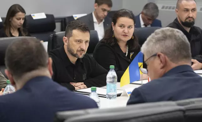 In this photo provided by the U.S. Army, Ukrainian President Volodymyr Zelenskyy, center, listens while visiting the Scranton Army Ammunition Plant in Scranton, Pa., Sunday, Sept. 22, 2024. (Sgt. 1st Class Curt Loter/U.S. Army via AP)