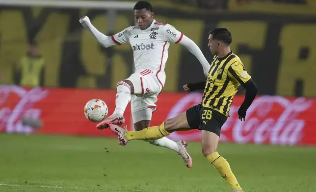 Gonzalo Plata of Brazil's Flamengo, left, and Jaime Baez of Uruguay's Penarol battle for the ball during a Copa Libertadores quarter final second leg soccer match at Campeon del Siglo Stadium in Montevideo, Uruguay, Thursday, Sept. 26, 2024. (AP Photo/Matilde Campodonico)