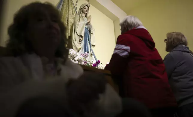 Pilgrims recite their prayers next to the statue of the Virgin Mary inside the St. James Church in Medjugorje, Bosnia, Thursday, Sept. 19, 2024. (AP Photo/Armin Durgut)