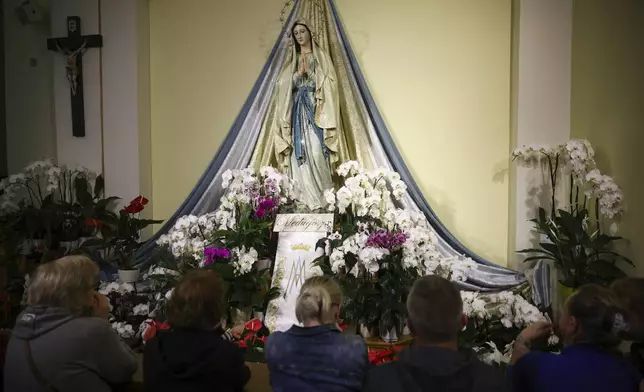 Pilgrims recited their prayers next to the statue of the Virgin Mary inside the St. James Church in Medjugorje, Bosnia, Thursday, Sept. 19, 2024. (AP Photo/Armin Durgut)