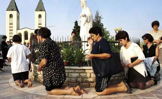 FILE - Bosnian Roman Catholic women pray on the occasion of the feast of the Assumption in Medjugorje, some 120 kilometers (75 miles) south of the Bosnian capital, Sarajevo, on Aug. 15, 2000. (AP Photo/Hidajet Delic, File)