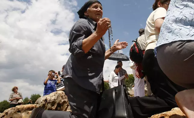 FILE - Pilgrims prays at the "Hill of Apparitions" in the southern-Bosnian town of Medjugorje, 100 kilometers south of Sarajevo, June 25, 2010. (AP Photo/Amel Emric, File)