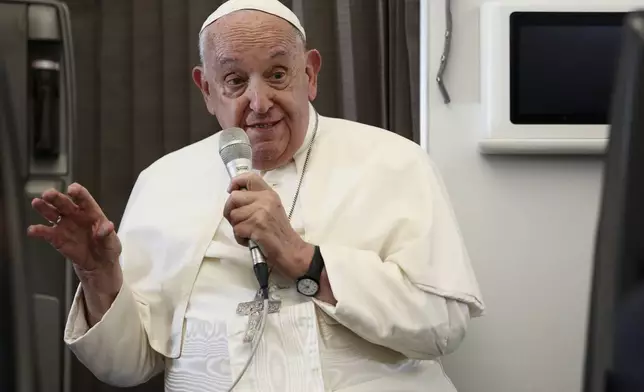 Pope Francis holds a news conference aboard the papal plane on his flight back after his 12-day journey across Southeast Asia and Oceania, Friday, Sept. 13, 2024. (Guglielmo Mangiapane/Pool Photo via AP)