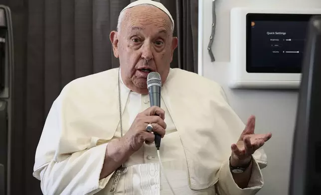 Pope Francis holds a news conference aboard the papal plane on his flight back after his 12-day journey across Southeast Asia and Oceania, Friday, Sept. 13, 2024. (Guglielmo Mangiapane/Pool Photo via AP)