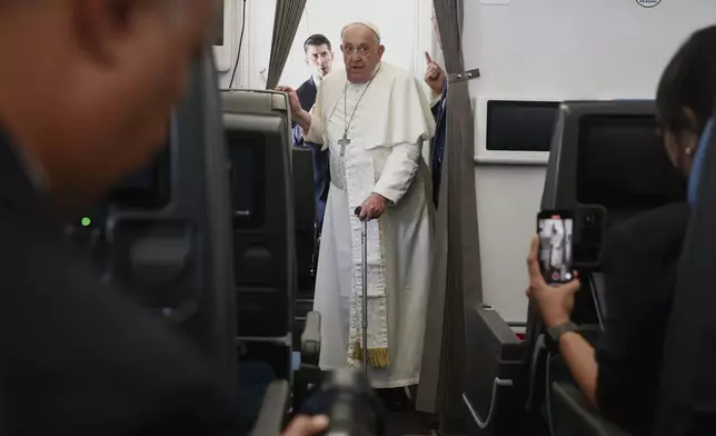 Pope Francis attends a news conference aboard the papal plane on his flight back after his 12-day journey across Southeast Asia and Oceania, Friday, Sept. 13, 2024. (Guglielmo Mangiapane/Pool Photo via AP)