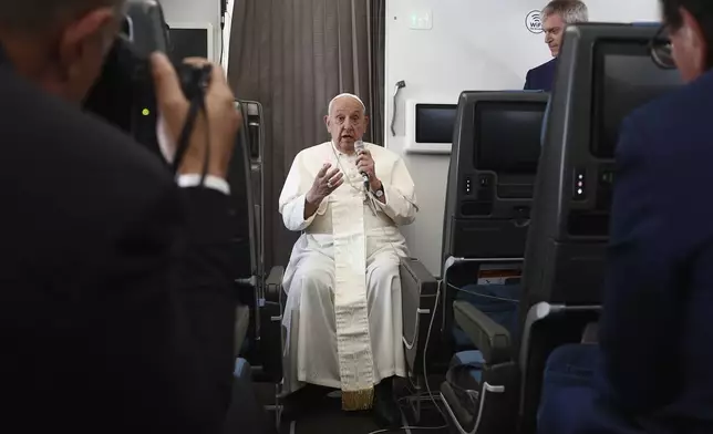 Pope Francis holds a news conference aboard the papal plane on his flight back after his 12-day journey across Southeast Asia and Oceania, Friday, Sept. 13, 2024. (Guglielmo Mangiapane/Pool Photo via AP)