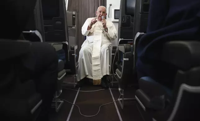 Pope Francis holds a news conference aboard the papal plane on his flight back after his 12-day journey across Southeast Asia and Oceania, Friday, Sept. 13, 2024. (Guglielmo Mangiapane/Pool Photo via AP)