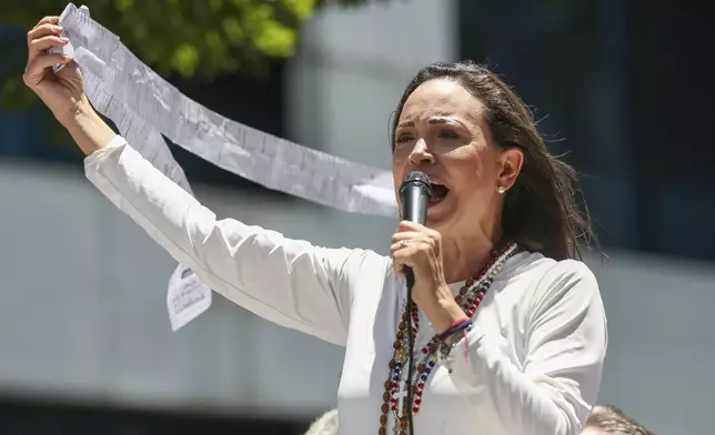 Opposition leader Maria Corina Machado displays vote tally sheets during a protest against the reelection of President Nicolás Maduro one month after the disputed presidential vote which she says the opposition won by a landslide, in Caracas, Venezuela, Wednesday, Aug. 28, 2024. (AP Photo/Cristian Hernandez)