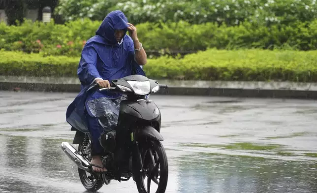 A man rides motorcycle in the rain caused by typhoon Yagi in Hanoi, Vietnam on Sep. 7, 2024. (AP Photo/Hau Dinh)