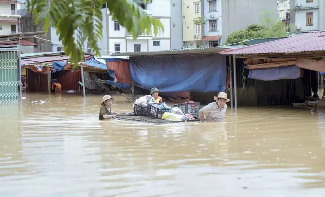 People carry belongings in flood triggered by Typhoon Yagi in Lang Son province, Vietnam Monday, Sept. 9, 2024. (Nguyen Anh Tuan/VNA via AP)