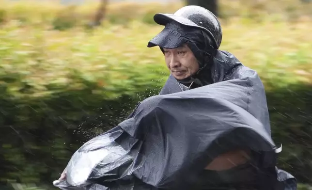 A man rides a motorcycle in the rain caused by typhoon Yagi in Hanoi, Vietnam Saturday, Sept. 7, 2024. (AP Photo/Hau Dinh)