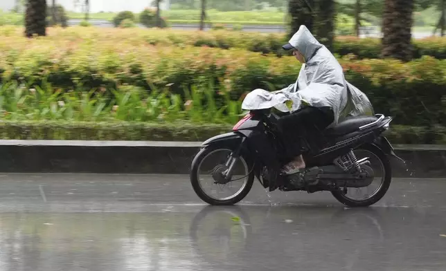 A man rides a motorcycle in the rain caused by typhoon Yagi in Hanoi, Vietnam Saturday, Sept. 7, 2024. (AP Photo/Hau Dinh)