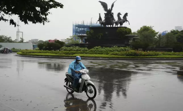 A man rides motorcycle in the rain caused by typhoon Yagi in Hanoi, Vietnam Saturday, Sept. 7, 2024. (AP Photo/Hau Dinh)