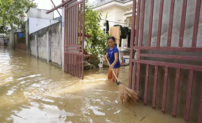 A woman cleans her house as flood recedes in the aftermath of Typhoon Yagi in An Lac village, Hanoi, Vietnam Friday, Sept. 13, 2024. (AP Photo/Hau Dinh)