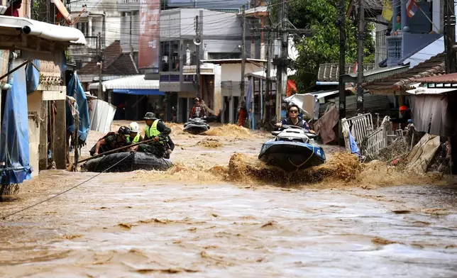 A rescue worker uses jet skis to search for victims in flooded areas in Chiang Rai Province, Thailand, Friday, Sept. 13, 2024. (AP Photo/Sarot Meksophawannakul)