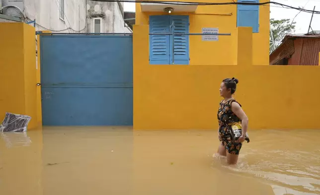 A woman wades in a flooded street in the aftermath of Typhoon Yagi, in Hanoi, Vietnam on Thursday, Sept. 12, 2024. (AP Photo/Hau Dinh)