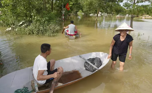 People use boats to get to their flooded homes in the aftermath of Typhoon Yagi in An Lac village, Hanoi, Vietnam Friday, Sept. 13, 2024. (AP Photo/Hau Dinh)