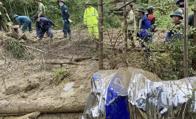 Rescue workers clear mud and debris brough down by a flood in Lang Nu hamlet in Lao Cai province, Vietnam Tuesday, Sep. 10, 2024. (Pham Hong Ninh/VNA via AP)