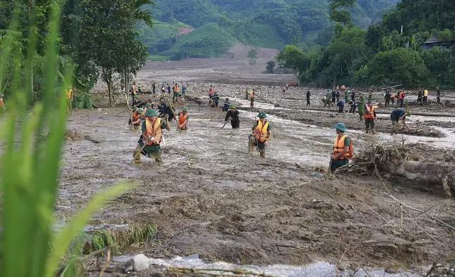 Rescue workers search for the missing after a flash flood buries a hamlet in mud and debris in the aftermath of Typhoon Yagi in Lao Cai province, Vietnam Thursday, Sept. 12, 2024. (Duong Van Giang/VNA via AP)